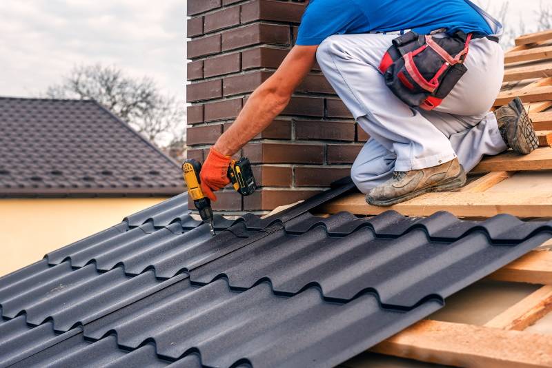 Builder fitting new roof tiles